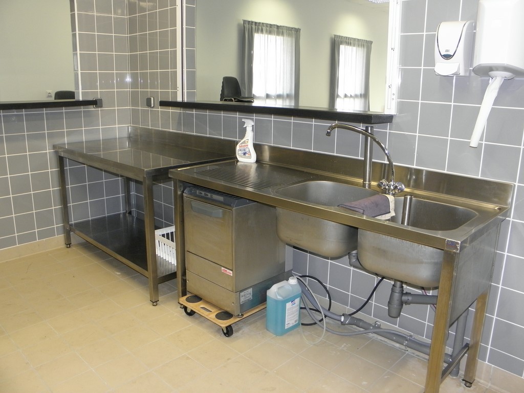 intérieur du bar avec table inox, lavabo et lave verres